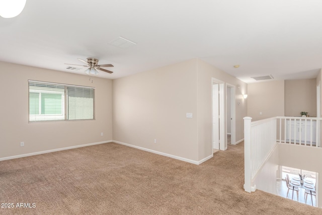 spare room featuring carpet flooring, visible vents, and baseboards