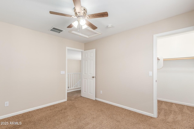 unfurnished bedroom with baseboards, light colored carpet, and a spacious closet