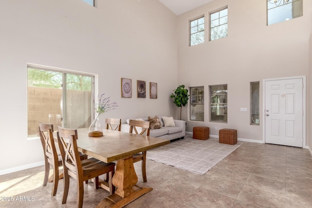 dining room featuring a high ceiling and baseboards