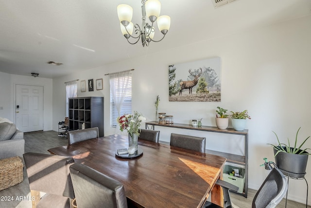 dining area featuring hardwood / wood-style floors and a notable chandelier