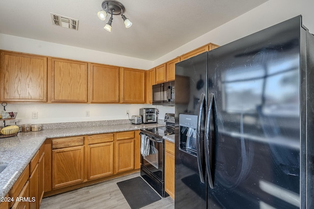 kitchen featuring light wood-type flooring and black appliances