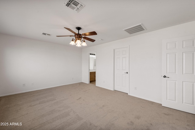 unfurnished bedroom featuring ceiling fan, light colored carpet, and ensuite bathroom