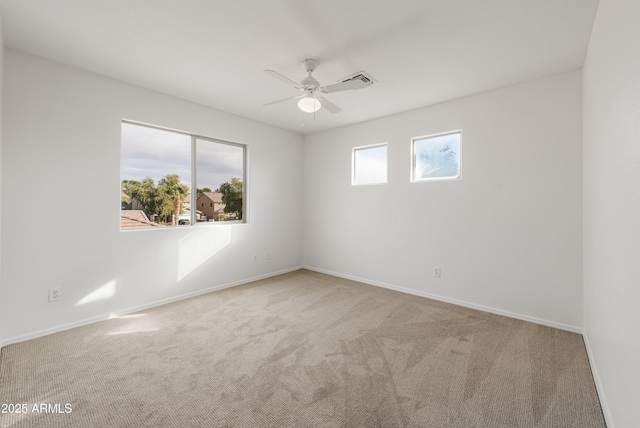 carpeted spare room with ceiling fan