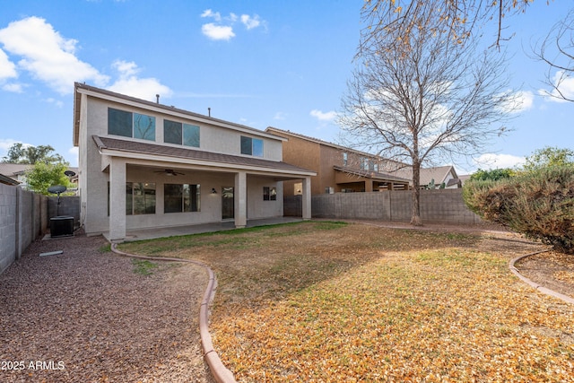 rear view of property with ceiling fan, cooling unit, and a lawn