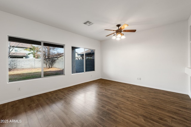 unfurnished room featuring plenty of natural light, ceiling fan, and dark hardwood / wood-style flooring