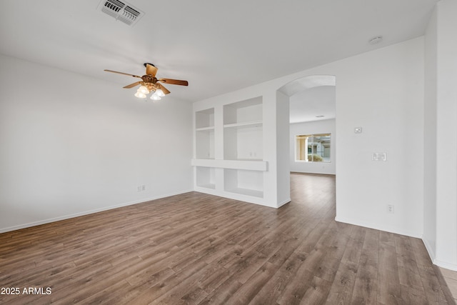 spare room featuring built in shelves, ceiling fan, and hardwood / wood-style flooring