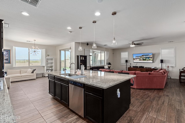 kitchen with an island with sink, ceiling fan with notable chandelier, dishwasher, hardwood / wood-style flooring, and sink