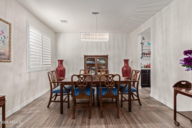 dining area featuring hardwood / wood-style floors and a chandelier