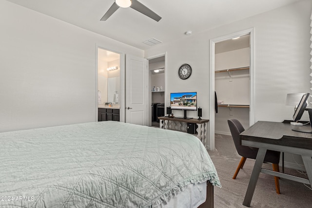 bedroom featuring a closet, carpet flooring, a walk in closet, ensuite bathroom, and ceiling fan