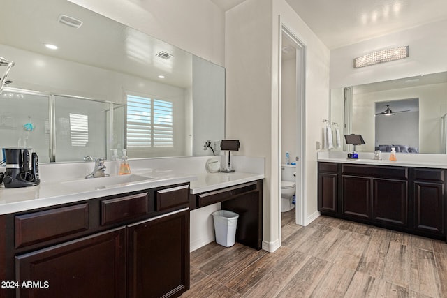 bathroom featuring vanity, wood-type flooring, an enclosed shower, and toilet