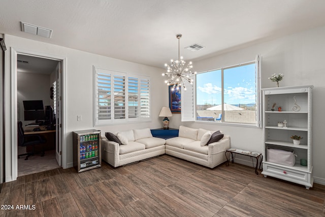 living room featuring an inviting chandelier, wine cooler, and dark wood-type flooring