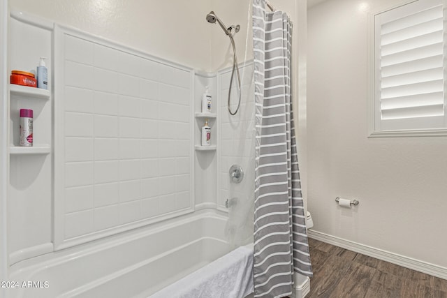 bathroom with hardwood / wood-style flooring, shower / tub combo, and toilet