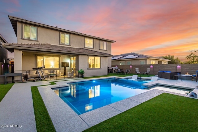 pool at dusk with a lawn, an outdoor living space, and a patio area