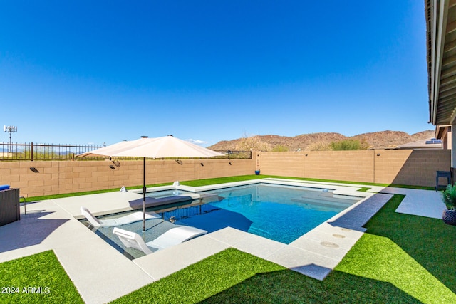 view of swimming pool with a patio, a yard, and a mountain view