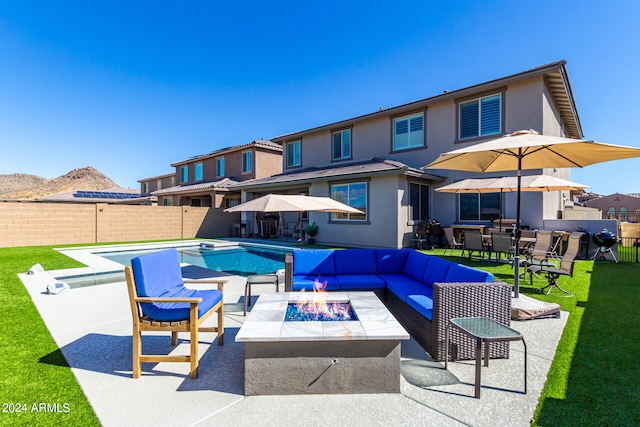 exterior space featuring a mountain view, an outdoor living space with a fire pit, and a fenced in pool