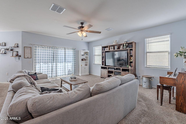 living room with ceiling fan, plenty of natural light, and light colored carpet