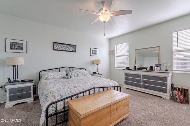 carpeted bedroom featuring ceiling fan and multiple windows