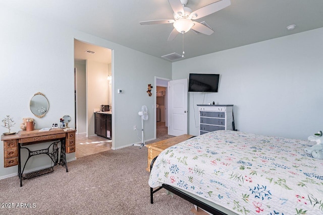 bedroom with ceiling fan, light colored carpet, and connected bathroom