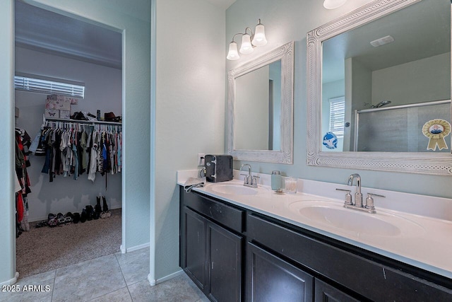 bathroom with tile patterned flooring, walk in shower, and vanity