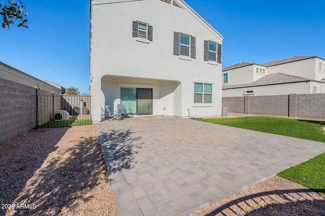 back of house with a lawn and a patio area