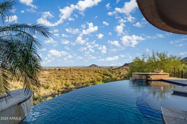 view of water feature featuring fence and a mountain view