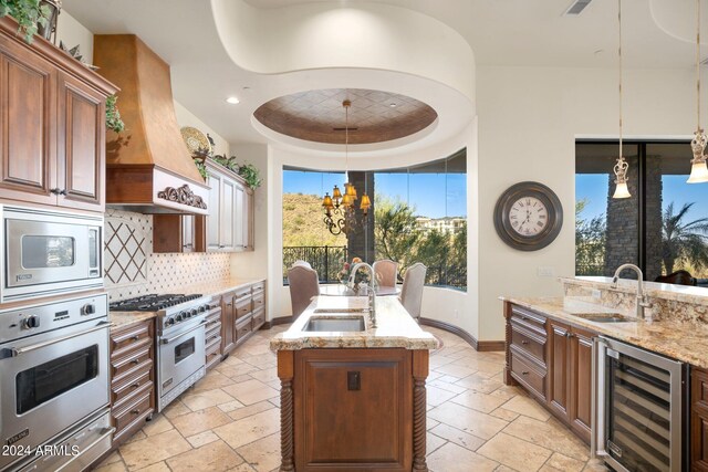 kitchen featuring stone tile flooring, stainless steel appliances, beverage cooler, and a sink