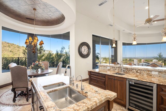 kitchen featuring wine cooler, visible vents, a tray ceiling, and a sink