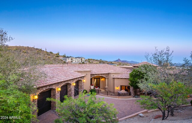 view of front of home with a tile roof, stucco siding, decorative driveway, stone siding, and a mountain view