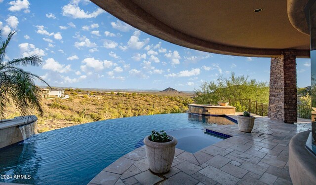 view of pool with an in ground hot tub and pool water feature