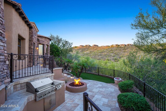 view of patio featuring an outdoor fire pit, a fenced backyard, and grilling area