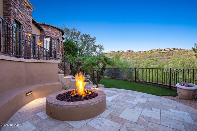 view of patio featuring a fire pit and fence