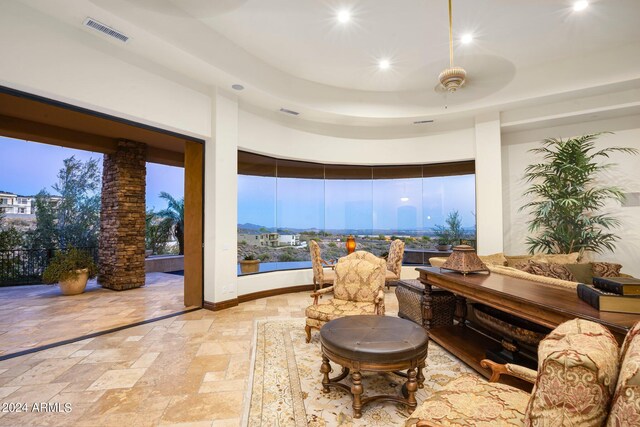 living area with visible vents, baseboards, recessed lighting, stone tile flooring, and a raised ceiling