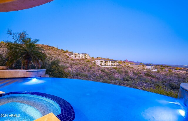 view of swimming pool featuring an in ground hot tub