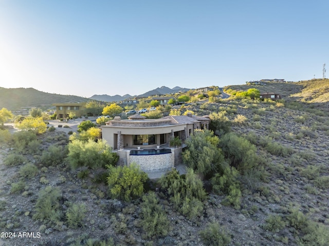 back of property featuring a mountain view and stucco siding