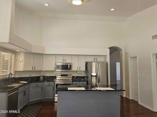 kitchen featuring sink, stainless steel appliances, high vaulted ceiling, dark hardwood / wood-style floors, and gray cabinets