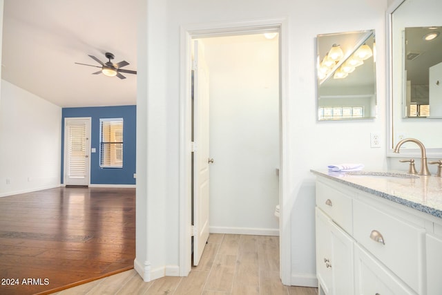 bathroom featuring ceiling fan, hardwood / wood-style floors, and vanity