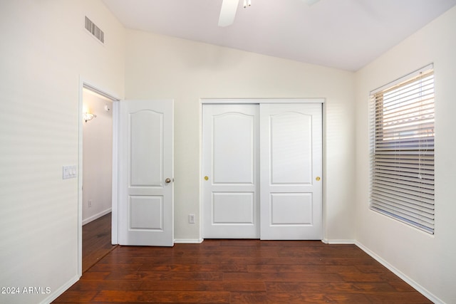 unfurnished bedroom with ceiling fan, vaulted ceiling, dark hardwood / wood-style flooring, and a closet