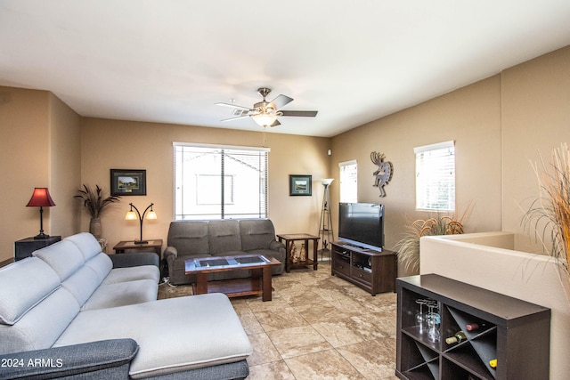 living room featuring ceiling fan and a wealth of natural light