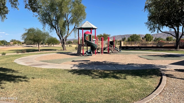 view of jungle gym with a yard and a mountain view