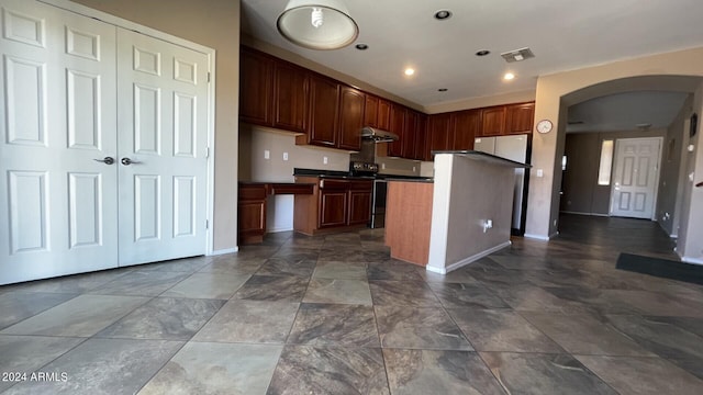 kitchen featuring stainless steel electric range oven, a kitchen island, and white fridge