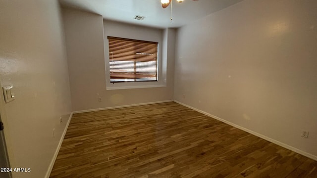 empty room featuring dark hardwood / wood-style flooring and ceiling fan