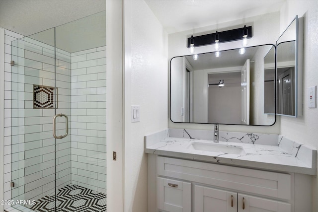 bathroom with a shower stall and vanity