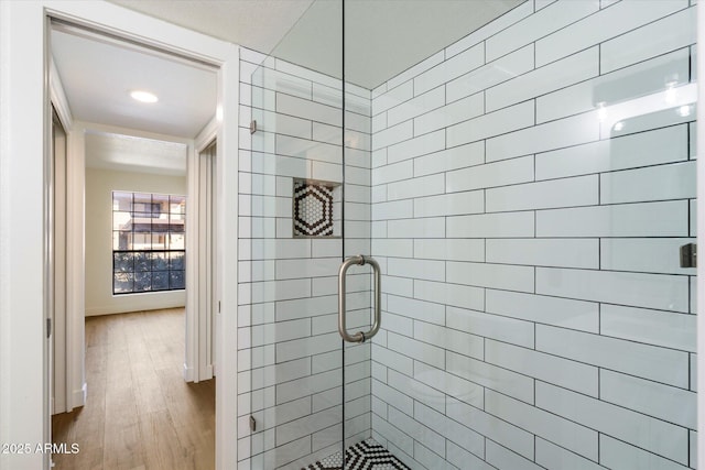 bathroom with a stall shower, wood finished floors, and recessed lighting