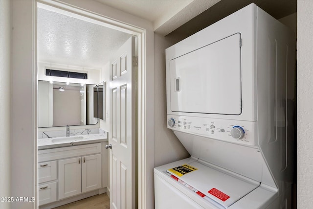 laundry room with stacked washer and clothes dryer and light wood-style flooring