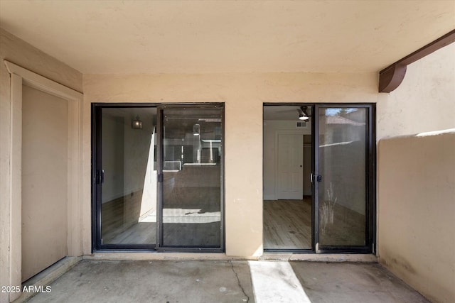 doorway to property featuring stucco siding