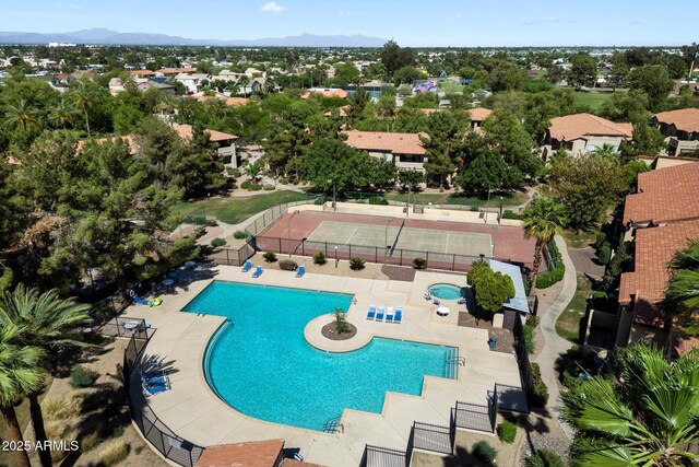 community pool with a mountain view and fence