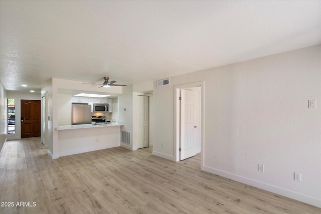 unfurnished living room featuring light wood-style floors, a ceiling fan, and baseboards