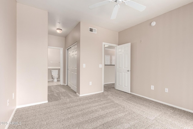 unfurnished bedroom with visible vents, carpet flooring, baseboards, and ensuite bath