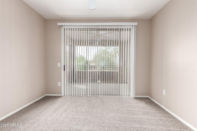 spare room featuring carpet floors and baseboards