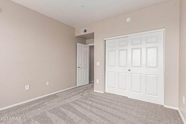 unfurnished bedroom with a closet, baseboards, carpet flooring, and visible vents